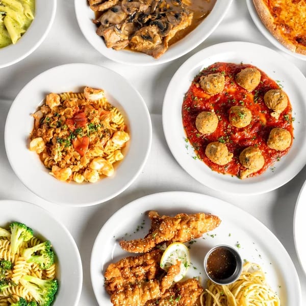 An overhead view of various Italian dishes, including pasta, pizza, meatballs, and chicken cutlets.