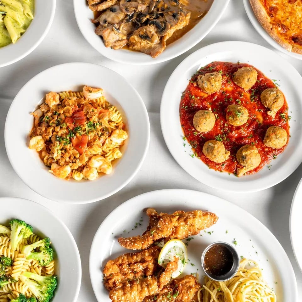 An overhead view of various Italian dishes, including pasta, pizza, meatballs, and chicken cutlets.