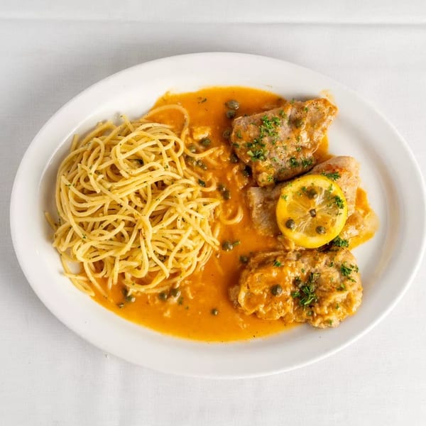 Chicken piccata with capers, lemon, and parsley, served with spaghetti in a rich orange sauce.